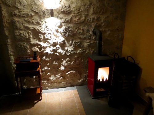 Das renovierte Wohnzimmer mit Steinoptik und Holzofen